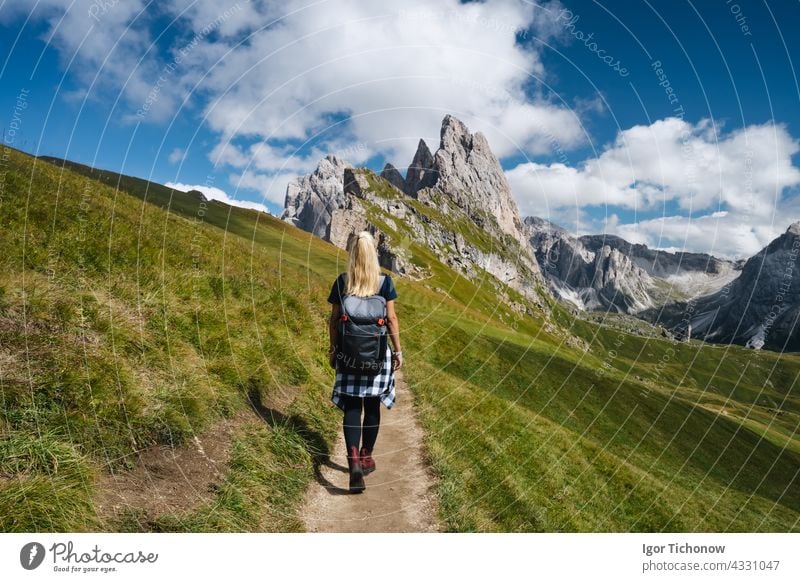 Women hiker on trail path and epic landscape of Seceda peak in Dolomites Alps, Odle mountain range, South Tyrol, Italy, Europe alps dolomites woman female italy