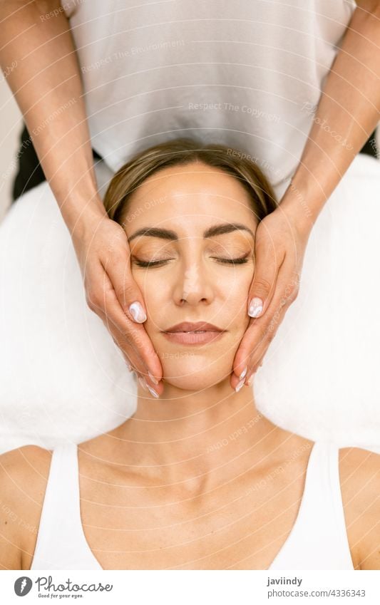 Middle-aged woman having a head massage in a beauty salon. female spa body relax massaging masseur wellbeing treatment care therapy wellness skin healthy