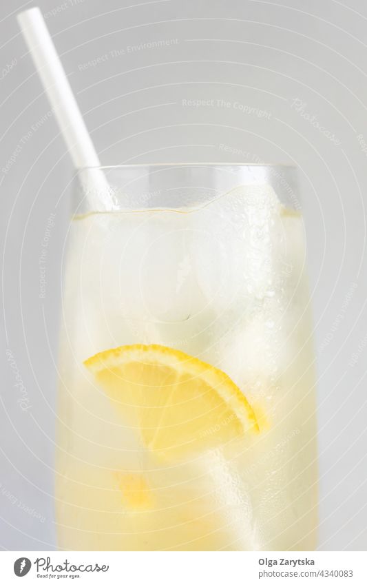 Glass of lemonade. drink cold water ice glass straw paper summer refreshment close up citrus perspiration beverage gray minimal cocktail background cool