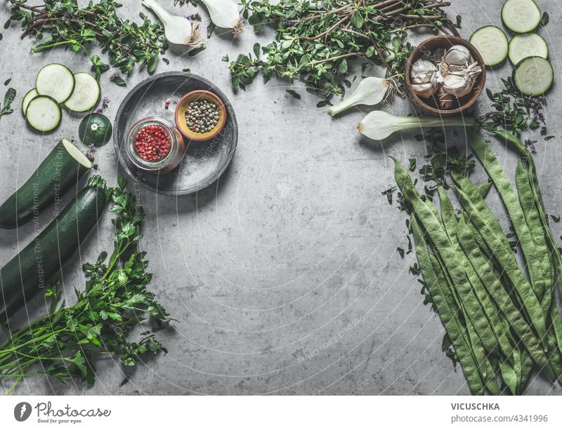 Various healthy green vegetables and herbs ingredients on concrete kitchen table background. Top view. Home cooking. Vegan food various top view home vegan food