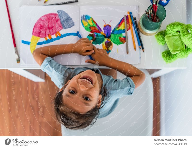 Top view of a girl painting at home on the table happy playful female children young happiness person art paper inspiration little education kindergarten