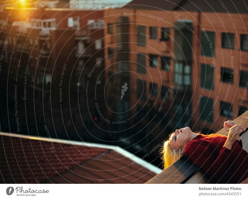 Portrait of a beautiful blonde woman in the roof of urban background model bokeh happy holiday maker girl sky beauty city cloud city landscape sunset young