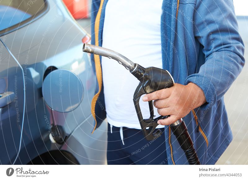 Close up of mans hand refueling a car at a petrol station adult auto automobile benzine bio caucasian cold column combustible control copy diesel driver filler