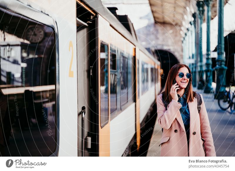 young backpacker caucasian woman at train station using mobile phone. Travel concept travel happy technology daytime Porto platform arrival baggage beautiful