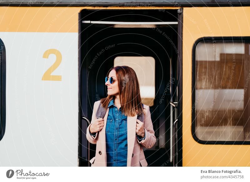 smiling young backpacker caucasian woman standing on wagon at train station. Travel concept mobile phone travel happy technology daytime Porto platform arrival