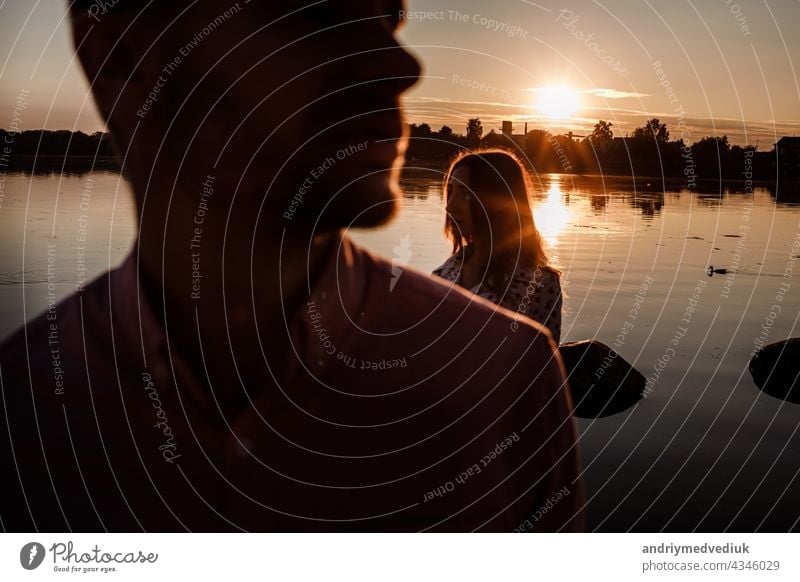 silhouette of couple in love near the lake on sunset. Lovely happy couple having fun near outdoors. happy holiday concept. selective focus young people romantic