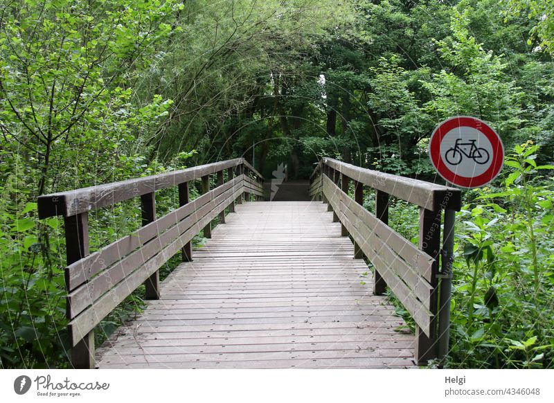 No bicycles! - Wooden bridge in the park with prohibition sign for cyclists Bridge Road sign interdiction Prohibition sign Ban for cyclists Tree shrub Park