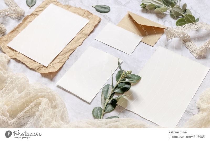 Wedding blank cards laying on a marble table decorated with eucalyptus branches mockup invitation envelope rustic close up ribbons retro RSVP vintage kraft