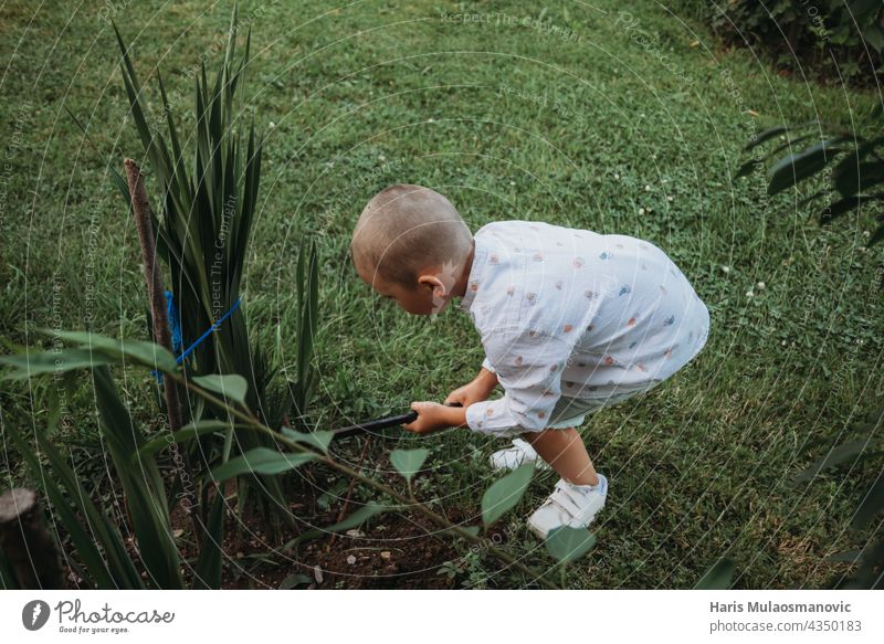 child ploughing plants with tools in the home garden Garden Gardening Summer activity Child children learning working Plant Plantation Vegetable vegetables