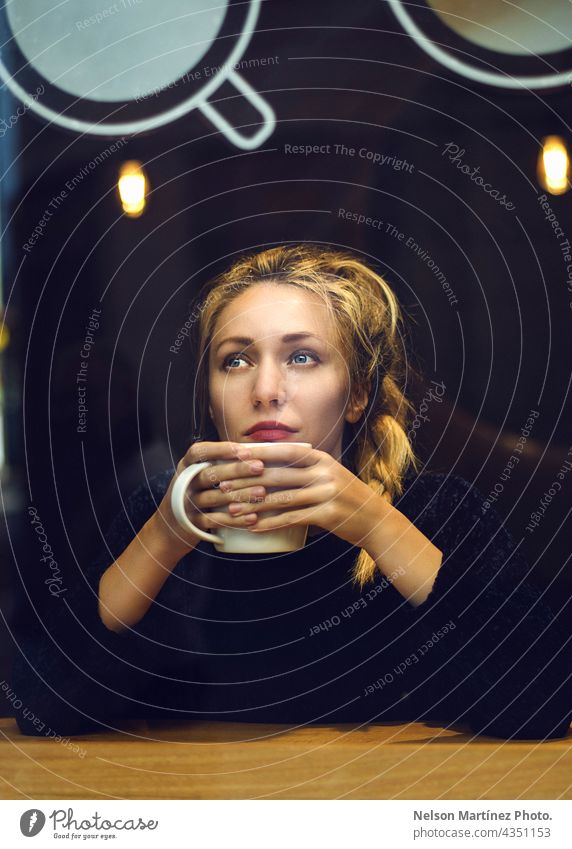 Portrait of a blonde woman holding a cup of coffee Cafeteria hot Hot drink Blonde Caucasian thoughtful lifestyle Beverage coffee shop mood cool moody Breakfast