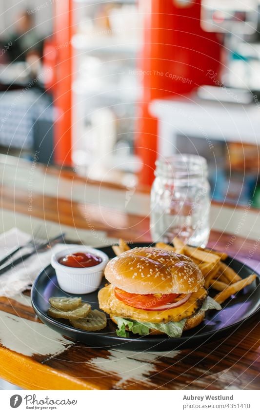 homemade cheeseburger meal with fries in a diner american background barbecue bbq beef big bread bun cheddar cuisine dark delicious dinner eating fast fastfood