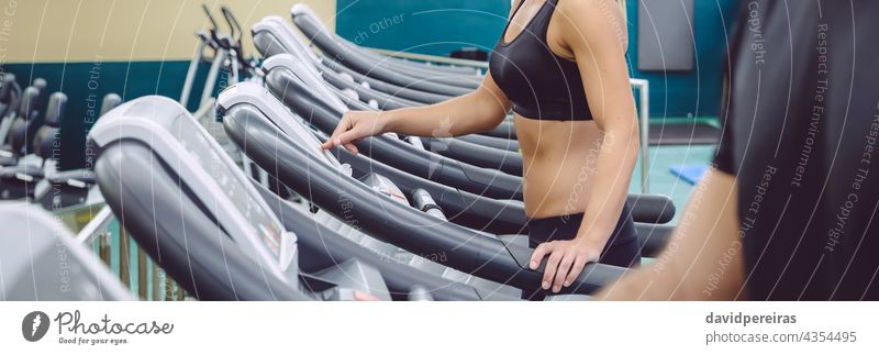 Unrecognizable woman setting control panel of treadmill for training panorama unrecognizable machine gym copy space run runner panoramic banner adjustment