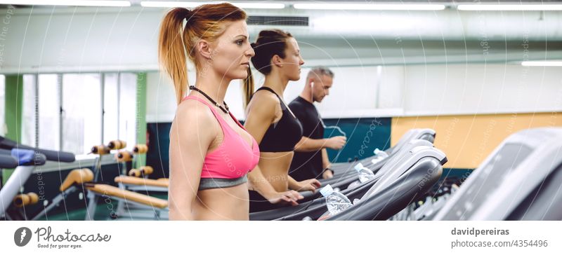 People training over treadmills on fitness center panorama people group woman machine copy space jogging warming up cardio running class sport banner exercise