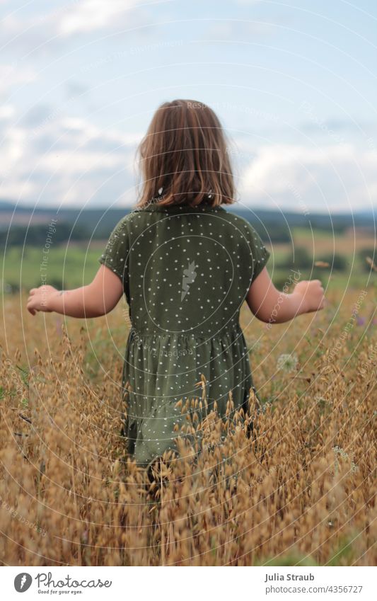 little girl running through an oat field with open arms Oats grains Ear of corn Girl midsummer Mature Dress Spotted short hair Rhön Nature by oneself Walking