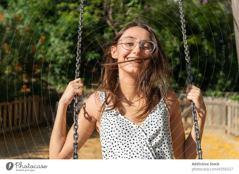 Smiling young woman swinging fun park portrait freedom summer play happy person female happiness girl leisure people adult beautiful lifestyle outdoor activity