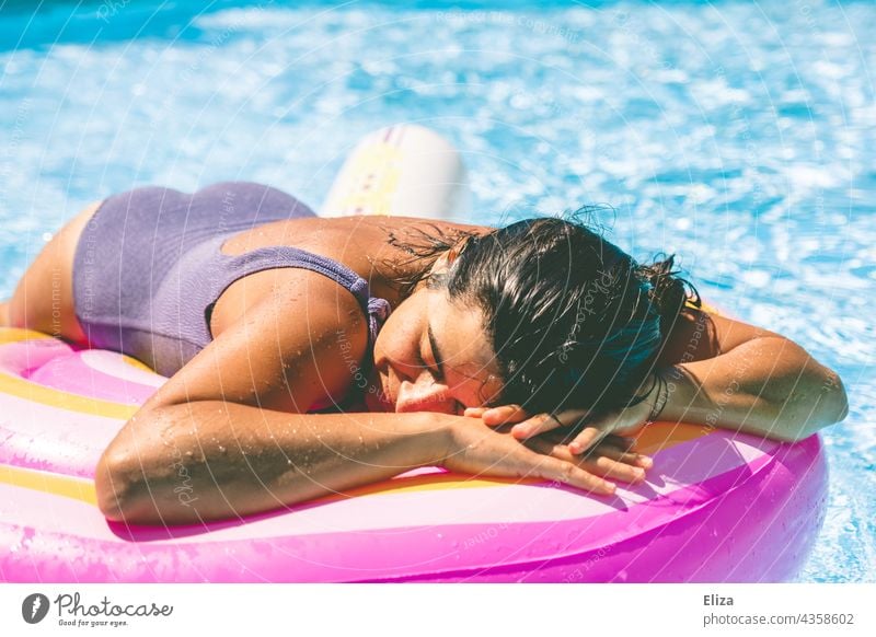 Woman with purple swimsuit lies in the pool on an air mattress and enjoys the sun Air mattress Swimsuit Summer Lie sunbathe Sun Relaxation vacation Water