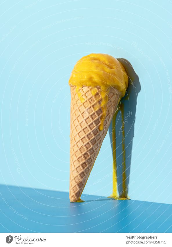 Melting ice cream on a blue background. Mango ice cream in a cone. abstract bright cold color concept creative delicious dessert drip flavor food frost frozen