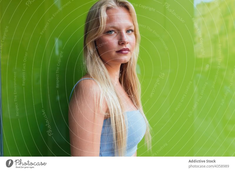 Charming woman winking at camera on green background blond charming style trendy beauty female positive happy feminine long hair modern carefree appearance