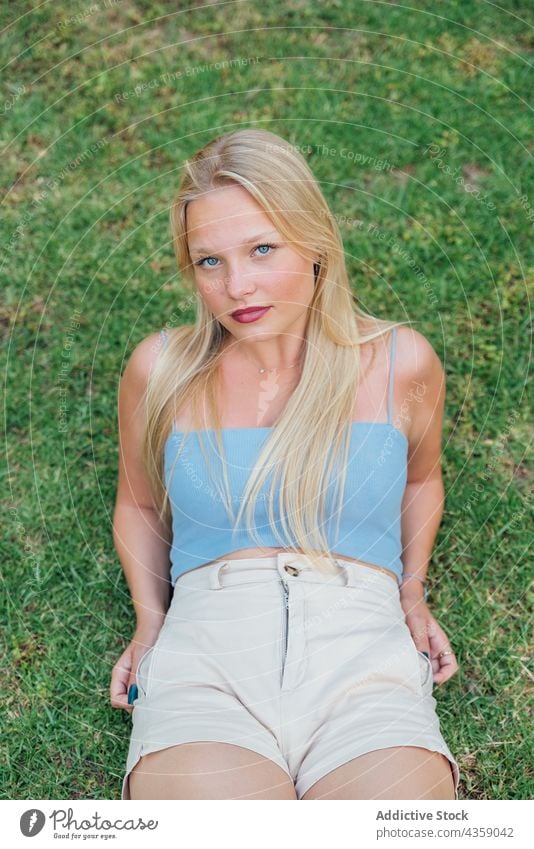 Woman sitting on green lawn in summer park woman meadow charming tranquil peaceful garden chill female nature grass harmony idyllic young carefree calm enjoy