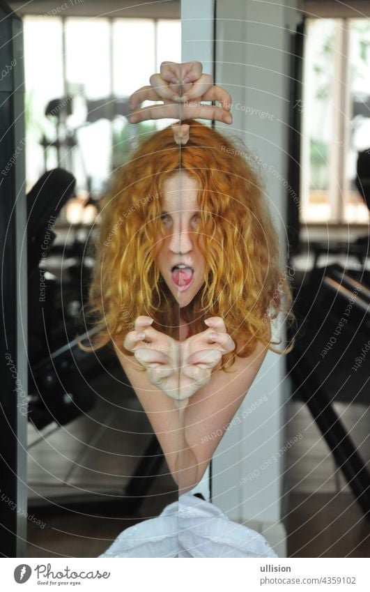 Portrait and hands of scary redhead woman with tongue out, creepy face in mirror, female duality, mental disorder, subconscious crisis portrait concept posing