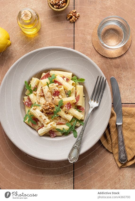 Dish of pasta with arugula, salami and walnuts rigatoni dish salad summer top view lemon mediterranean fresh delicious close up pasta salad oil cooked