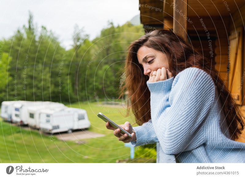 Pensive woman browsing on smartphone on terrace of house mountain thoughtful vacation travel traveler using female pyrenees holiday enjoy pensive communicate