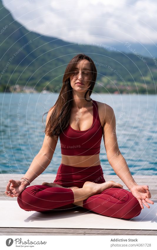 Beautiful female model meditating in lotus yoga pose