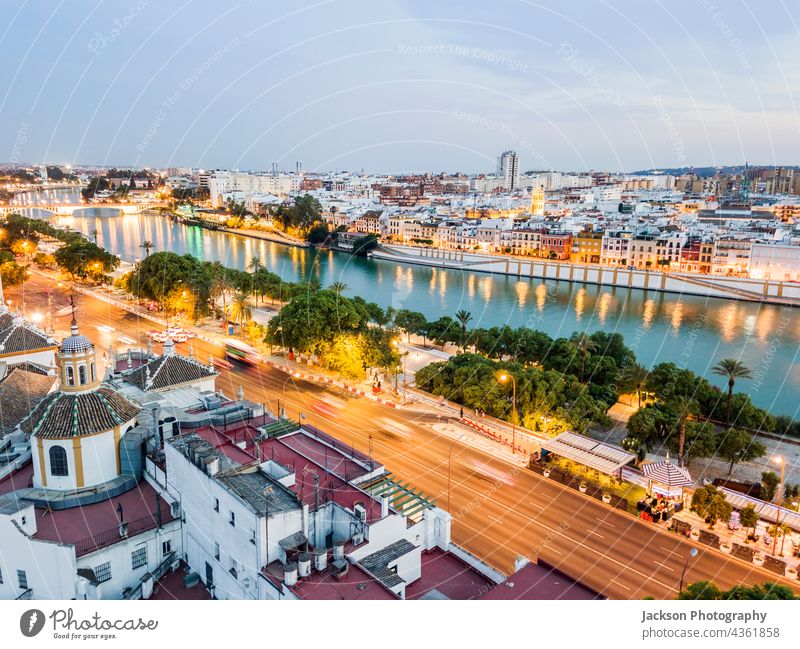 Aerial view of historic part with the river in Seville by the evening, Spain seville spain cityscape aerial illuminated water night old panorama landscape sky
