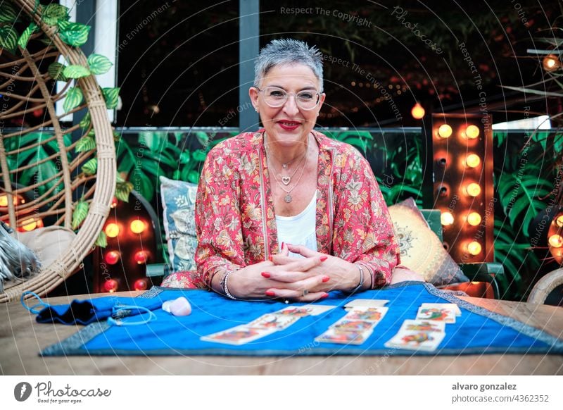 mature woman with grey hair using tarot cards to predict future caucasian adult confident elder witch female fortune portrait prophet mystery mystic reading