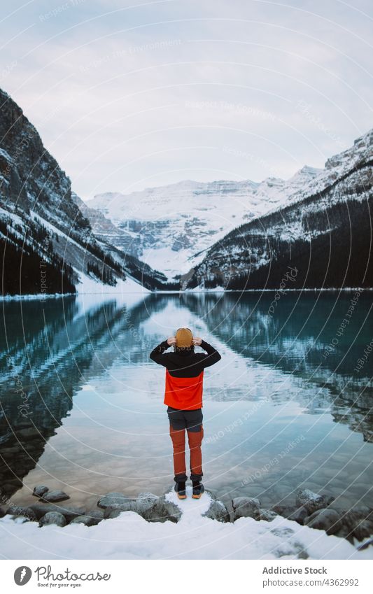 Unrecognizable tourist standing on shore of calm lake - a Royalty Free  Stock Photo from Photocase