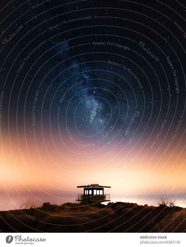 Lifesaver house under starry sky at night milky way galaxy spectacular astronomy lifesaver nature hill tower breathtaking scenic dark universe cosmos amazing