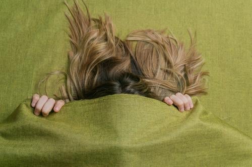 Long haired woman hiding under green cloth color cover face hide fair hair long hair fabric female enigma concept verdant lady finger unknown shy secret