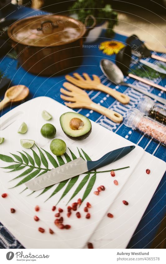 flat-lay of stylized cooking supplies on a picnic table avocado blue camping chef cookware culinary cutting board flat lay food kitchen knife lime guacamole