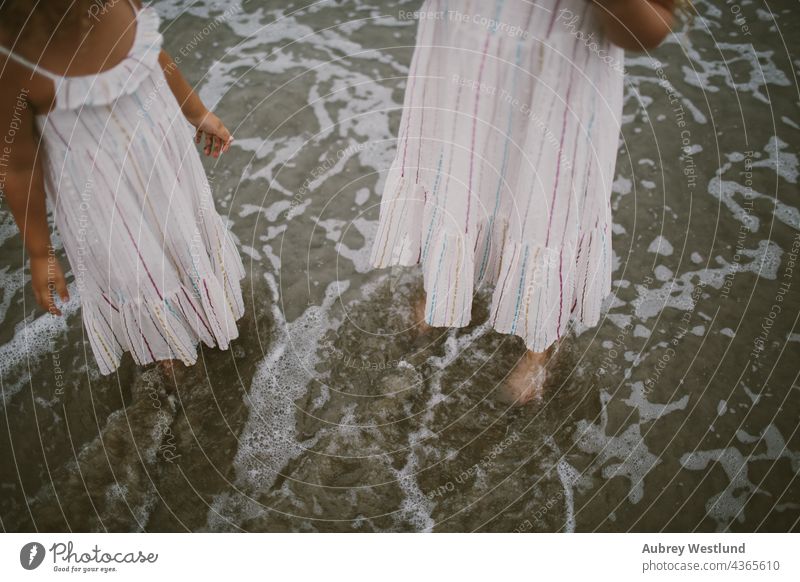 girls in matching dresses with feet in the ocean 0-5 5-10 beach california curly hair fall family landscape little outdoors pacific beach people pier playing