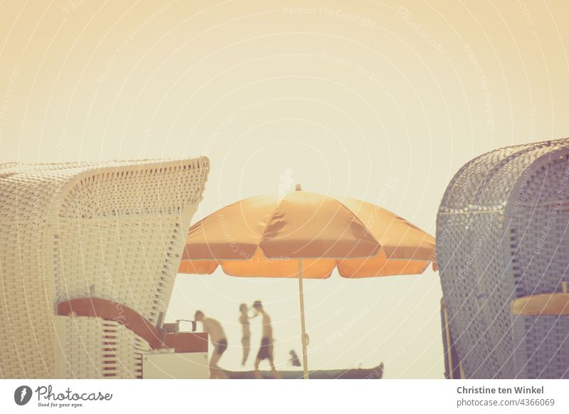 Spaces | on the beach ... Two beach chairs and in between an orange parasol and shadowy silhouettes of people in the back light Beach chair Summer Ocean