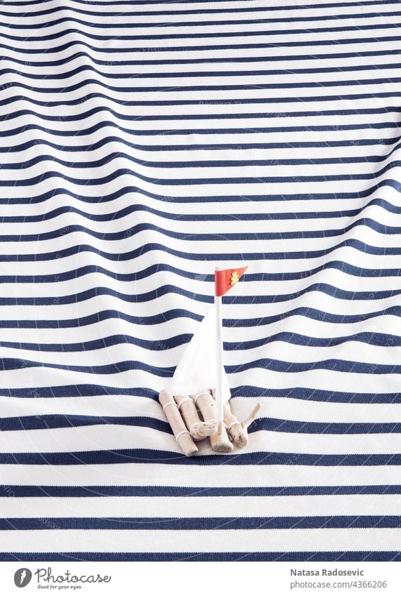 Wooden raft with a white sails on a sailor's shirt instead of the sea. background summer concept Abstract marine Contemporary Rectangle aesthetic art blue boat