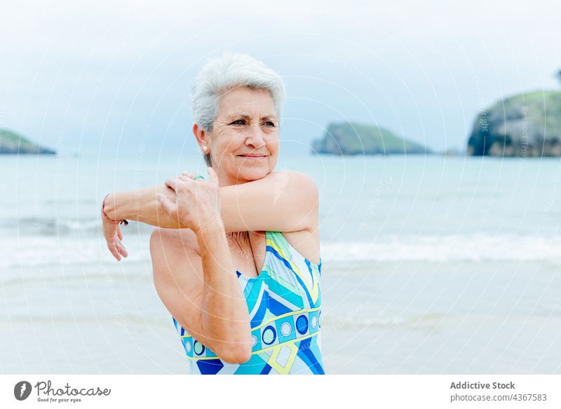 Happy senior woman exercising near ocean - a Royalty Free Stock Photo from  Photocase