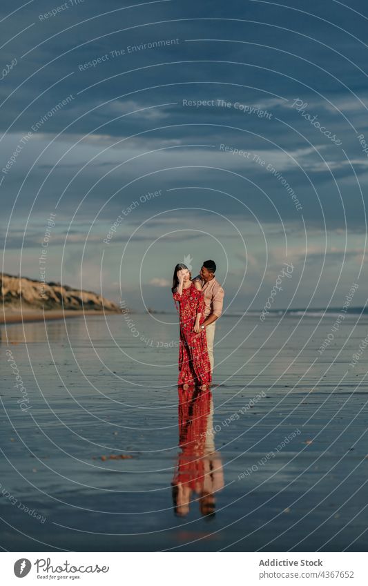 Tender multiethnic couple embracing on beach embrace love from behind seashore tender serene hug relationship multiracial diverse black african american