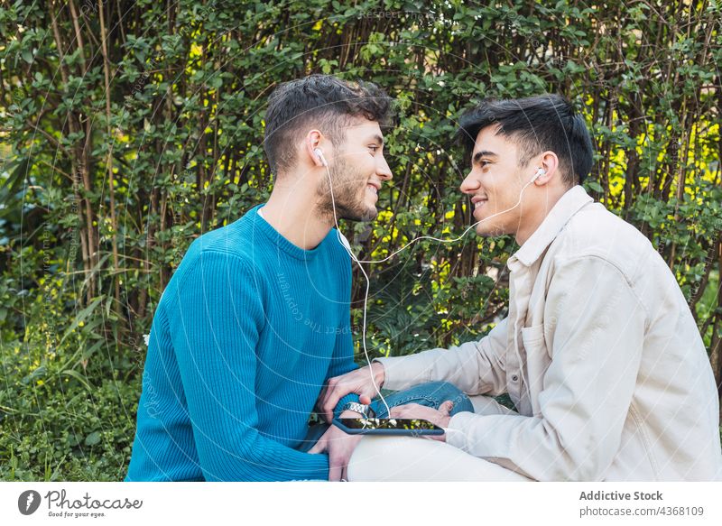 Gay couple chilling on meadow in park men lgbt enjoy homosexual together cheerful gay relationship male smile love boyfriend lawn same sex lgbtq spend time