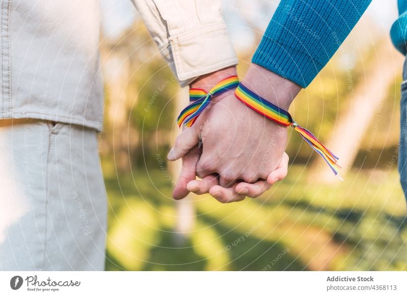 Crop homosexual men in rainbow bracelets holding hands in park gay couple lgbt lgbtq love male together equal tolerance partner boyfriend unity right gender