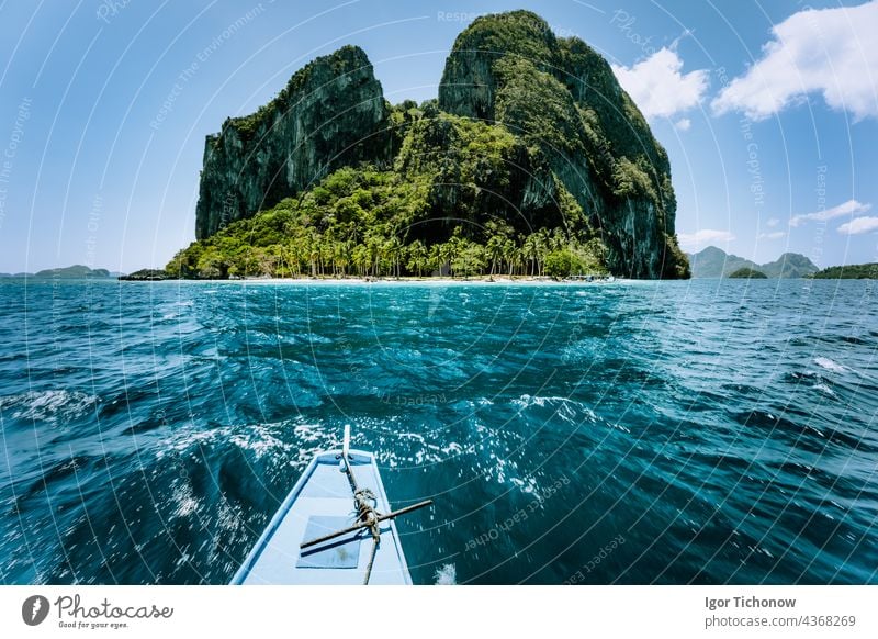 Local banca boat approaching amazing tropical island tour trip to the protected famous archipelago Bacuit El Nido, attractions tourist locations Palawan in the Philippines