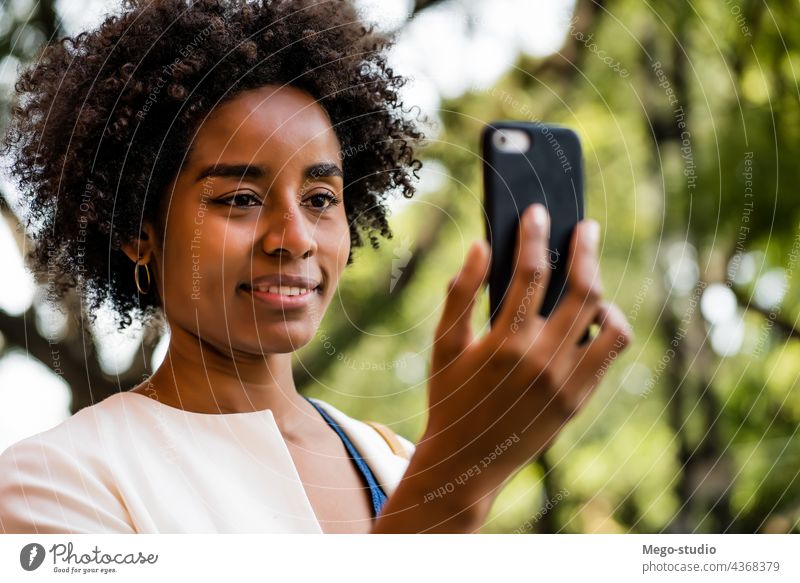 Afro business woman having a video call on mobile phone. afro app cellular talking communication outdoors software looking portrait wireless network person