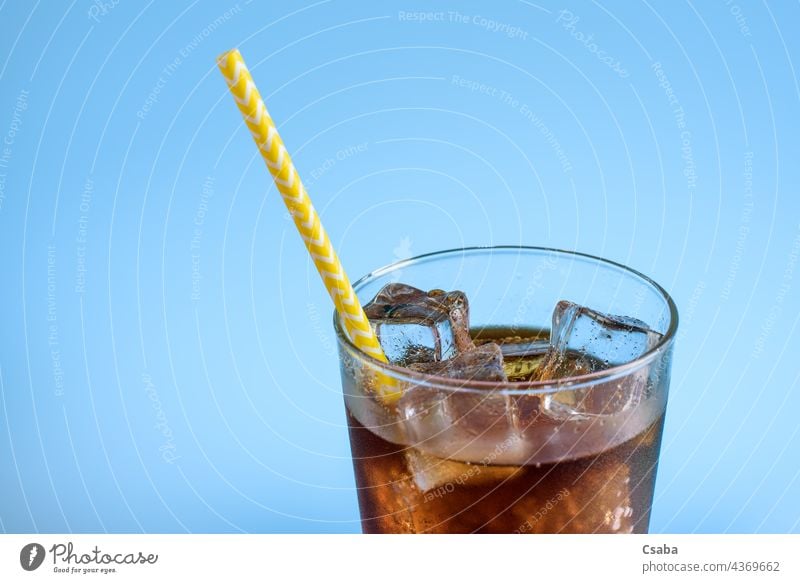 A glass of cola with ice on a blue background Cola Soda Soda Glass Soft Drinking Ice Cold Straw Summer Refreshment Caffeine Liquid Blue Brown Beverage