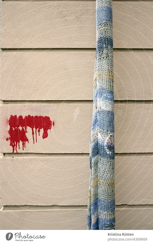 rain tube with rope and painted over graffiti guerilla crickets Guerilla Knit urban knitting yarn bombing Downpipe street art out Public Knitted embroidered