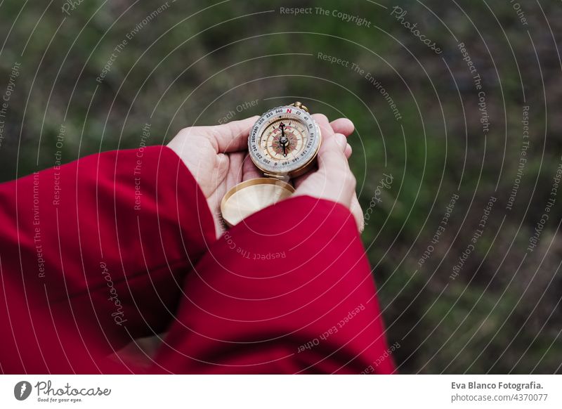 unrecognizable woman hands holding compass in forest. top view. Hiking and nature caucasian hiking backpacker navigation orienteering leisure guide searching
