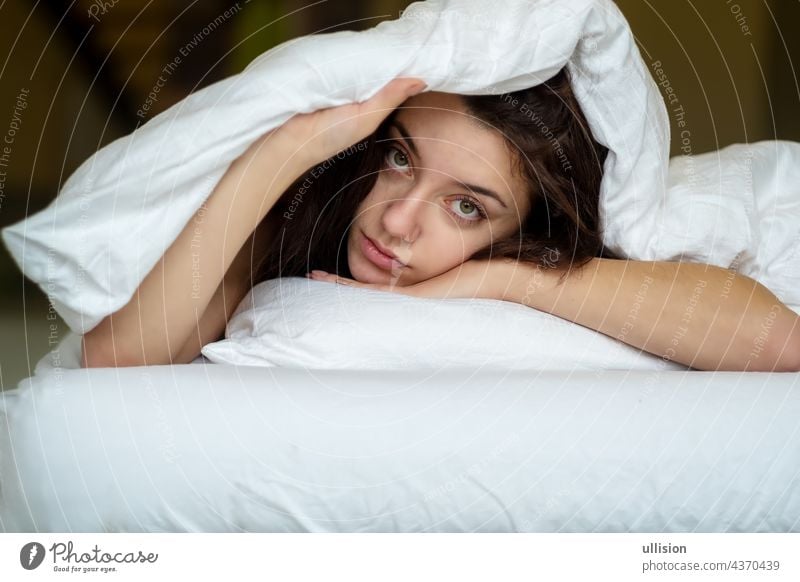 Portrait of an attractive, young, sexy brown haired woman in Bed