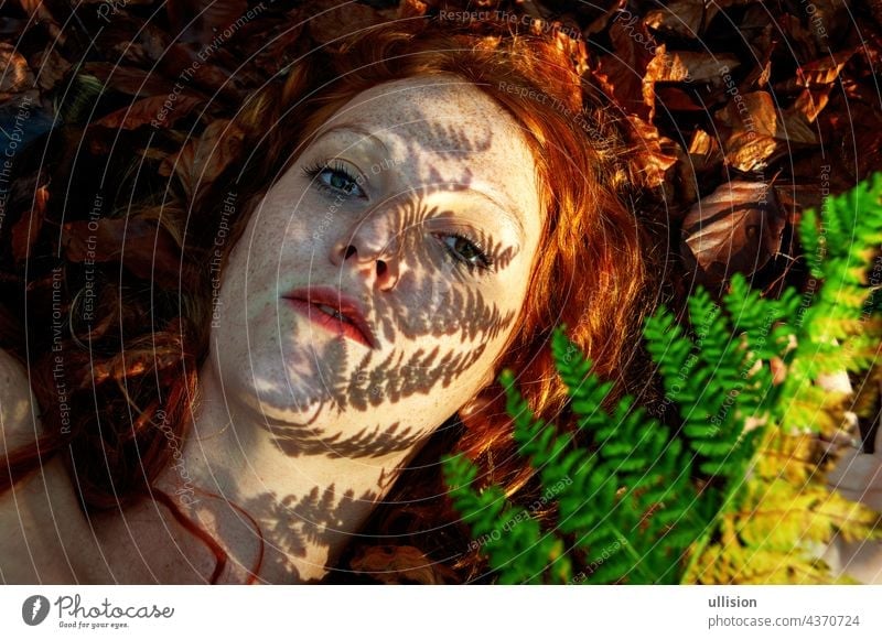 lovely portrait of a young seductive foxy girl in autumn, with shadow of fern frond on face, beautiful sexy attractive redhead woman forest ginger freckles