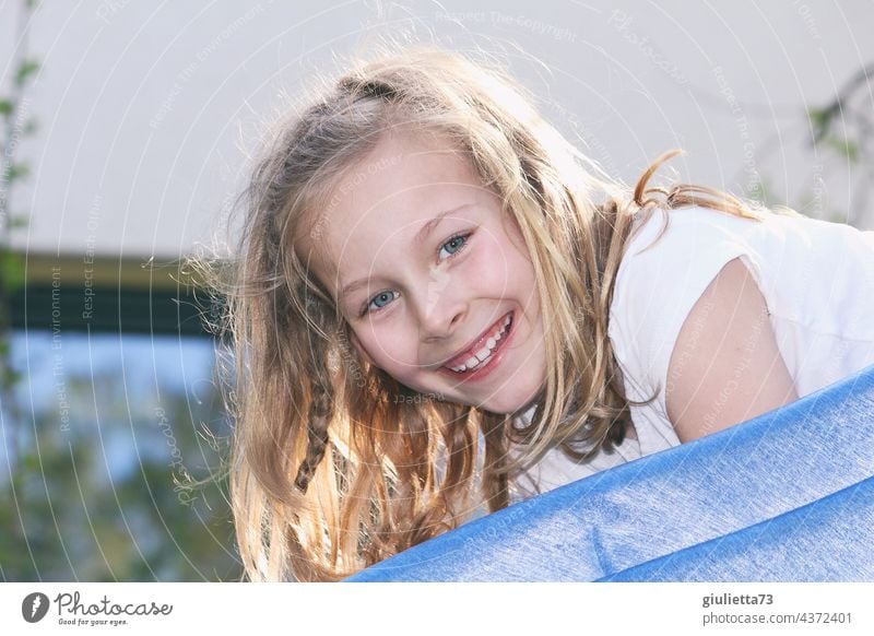 Portrait of a happy, laughing 8 year old girl with long blond hair playing on the slide Child Girl 1 Infancy Human being 8 - 13 years Summer Blonde Long-haired