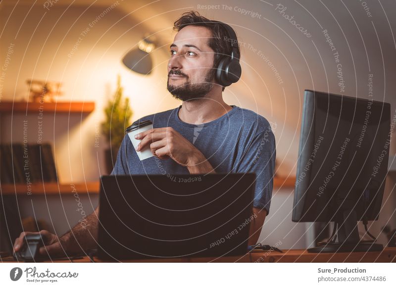 A middle-aged student with a beard is engaged in the evening with headphones and coffee university knowledge science dissertation doctor master Education