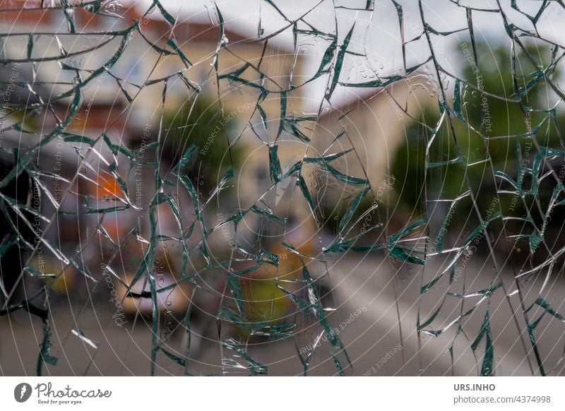through the heavily shattered glass window pane you can still see the houses in the background Slice Window Window pane Glass Pane Transparent Exterior shot